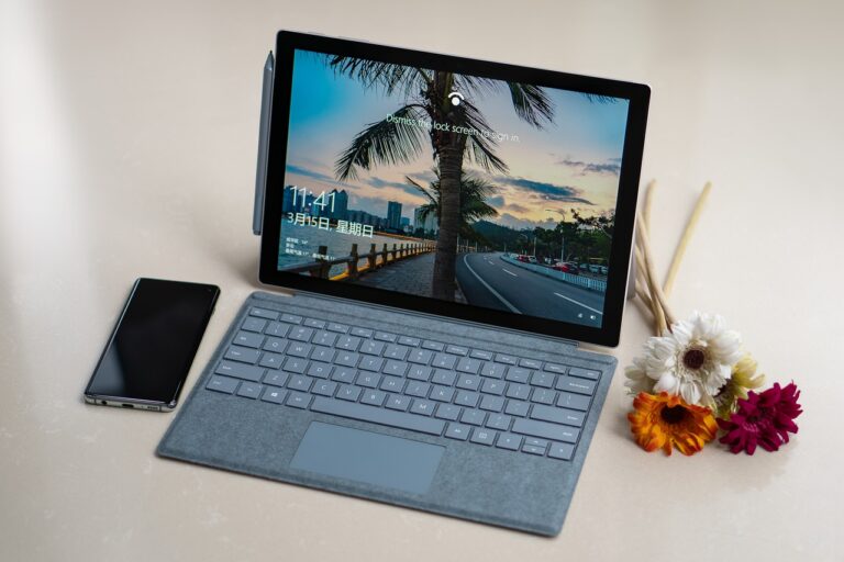 Microsoft Surface Pro 7+ with flowers and mobile phone is in the table.