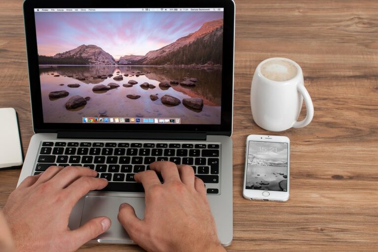 Microsoft Surface Go in the hands of human near the coffee and mobile phone in the desk.