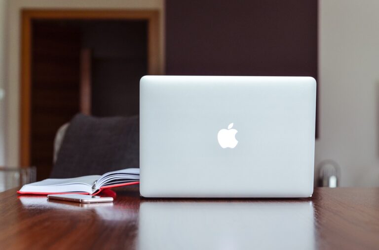 Apple MacBook Air 2022 with a book is in the brown desk.