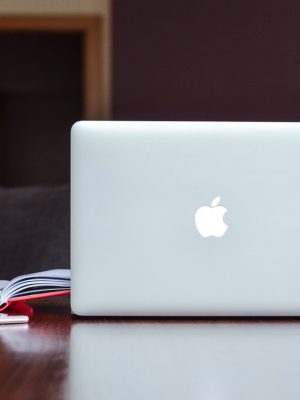 Apple MacBook Air 2022 with a book is in the brown desk.